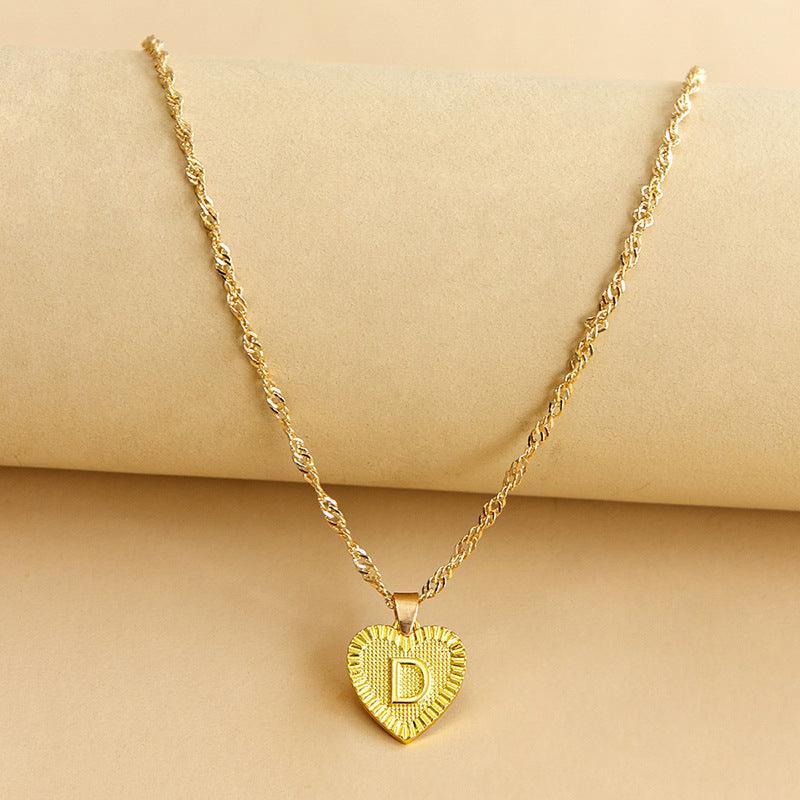 Close-up of a women's gold initial heart pendant, elegant and personalized.