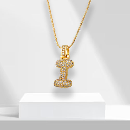Detailed shot of a women's gold plated bubble letter pendant, accented with glittering zirconia.