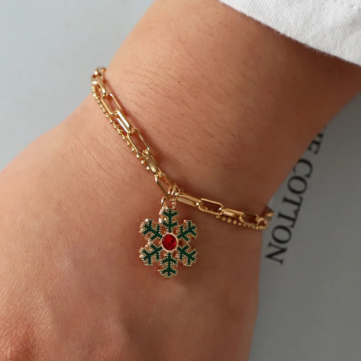 Women's gold-plated Christmas charm bracelet with festive enamel charms.