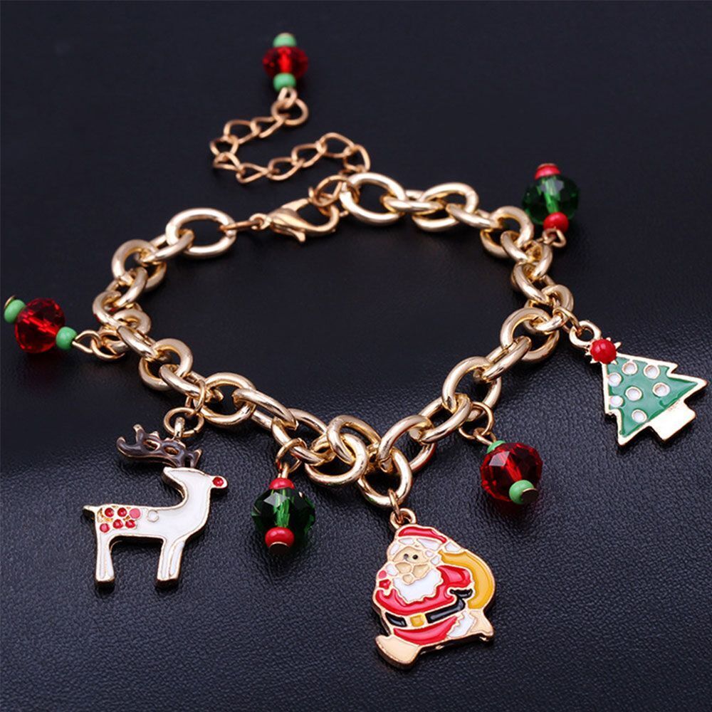 Close-up of a women's festive Christmas charm bracelet, featuring shimmering rhinestones and gold plating.