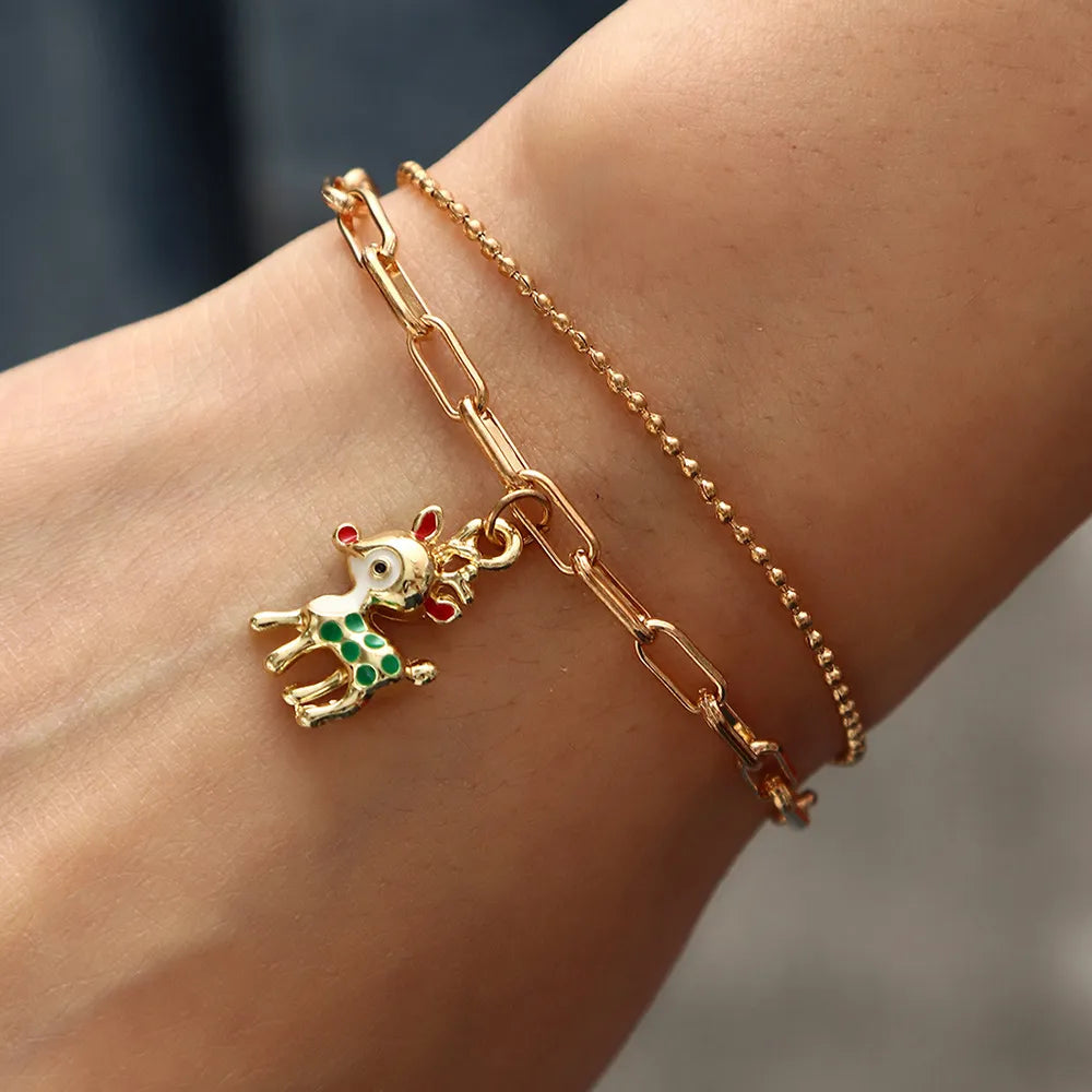 Festive gold-plated charm bracelet for women, with colorful enamel Christmas holiday charms.