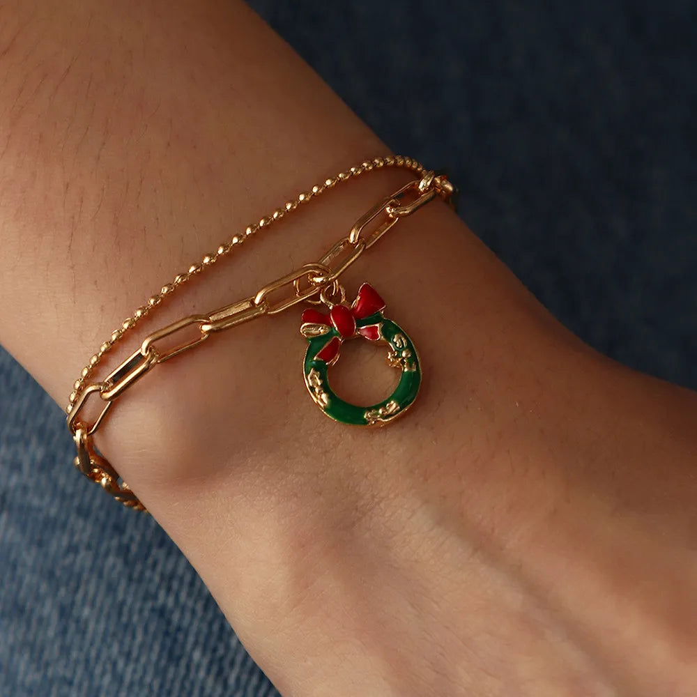 Detailed view of a gold-plated Christmas charm bracelet with enamel festive designs.