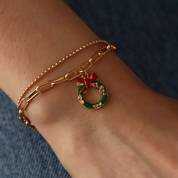 Detailed view of a gold-plated Christmas charm bracelet with enamel festive designs.