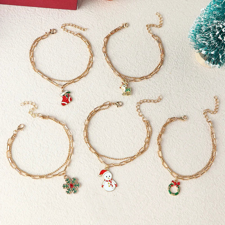 Woman wearing a festive gold-plated Christmas charm bracelet, perfect holiday accessory.