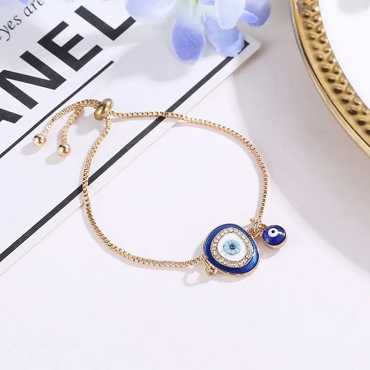 Ethnic style women's evil eye bracelet, gold plated with a vibrant blue sparkling charm, spiritual protection jewelry.