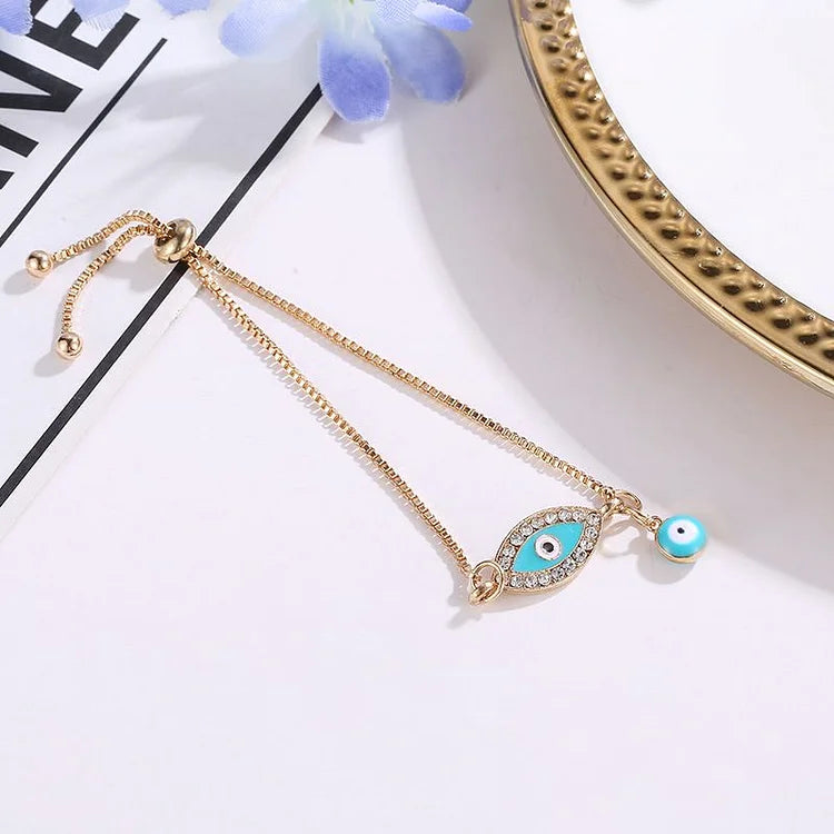Women's ethnic evil eye bracelet, gold plated with a sparkling blue charm. A stylish piece of spiritual protection jewelry.