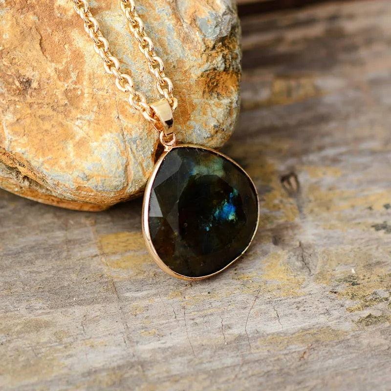 Close-up of a women's gold plated labradorite drop pendant necklace, showcasing iridescent gemstone.