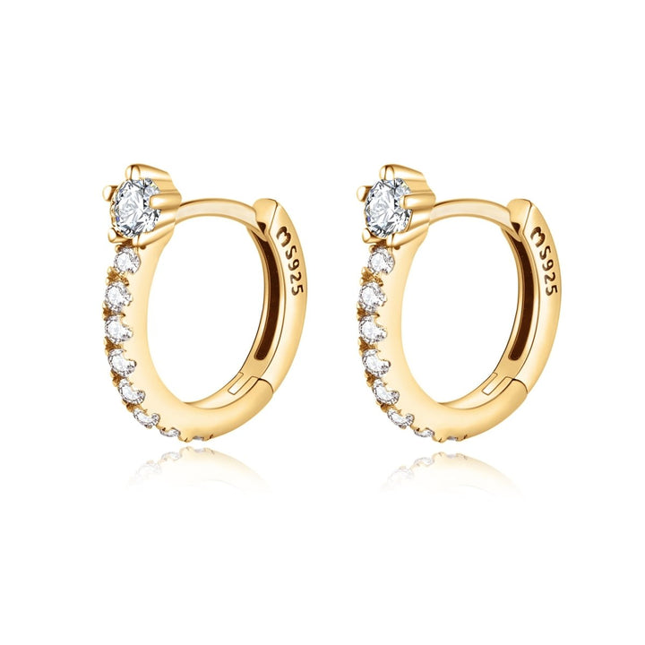 Close-up of sparkling hoop earrings, gold plated with zirconia. Dainty women's jewelry, perfect for any outfit.