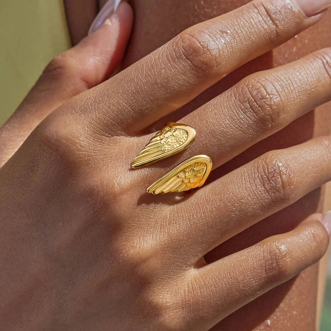 Delicate women's adjustable gold plated angel wing feather ring, representing guardian protection & celestial style.