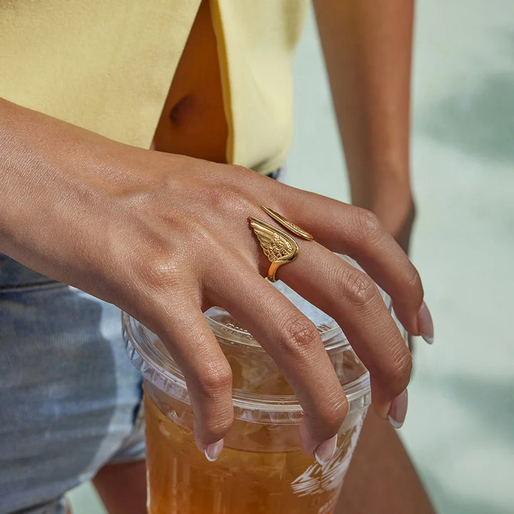 Women's adjustable gold plated stainless steel angel wing feather ring, unique celestial protection jewelry.