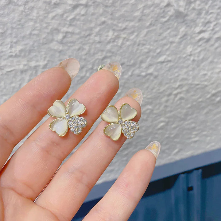 Elegant four-leaf clover drop earrings. Gold-plated sterling silver lucky charm jewelry for women. Perfect accessory.