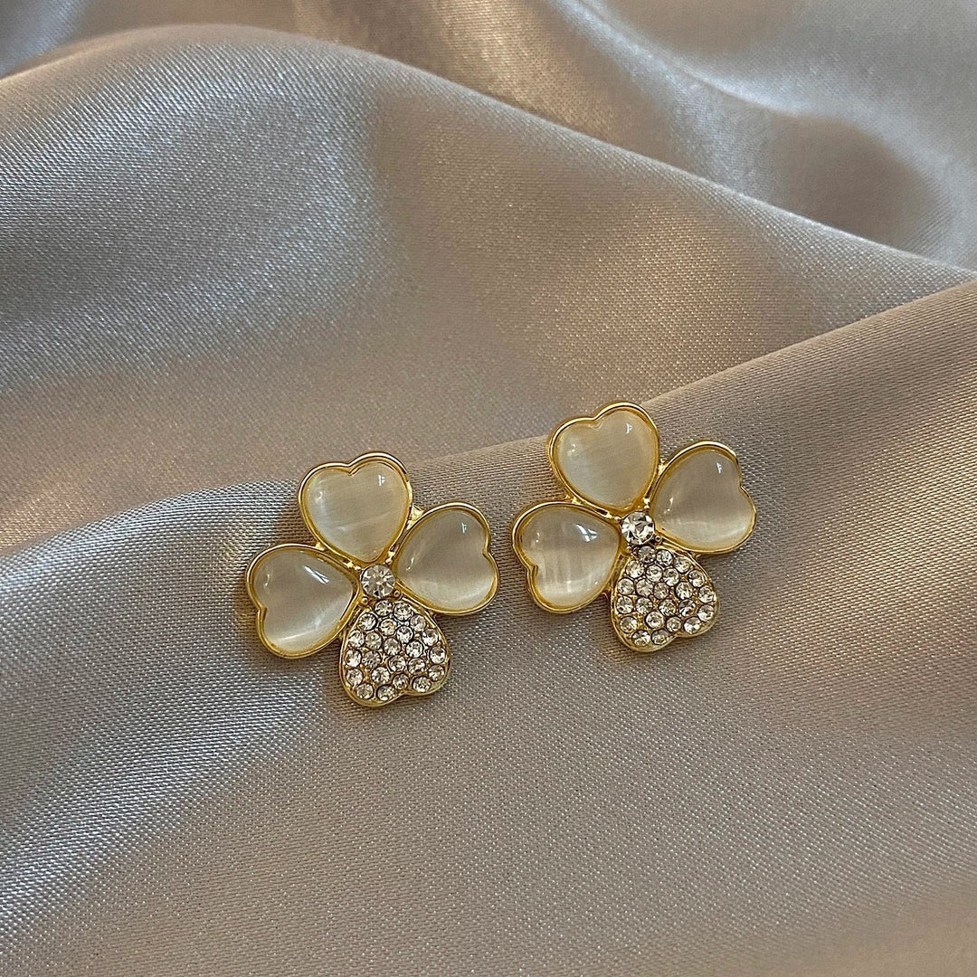 Delicate four-leaf clover drop earrings in gold-plated sterling silver. Women's lucky charm jewelry, perfect for gifting.