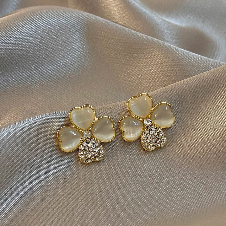 Delicate four-leaf clover drop earrings in gold-plated sterling silver. Women's lucky charm jewelry, perfect for gifting.