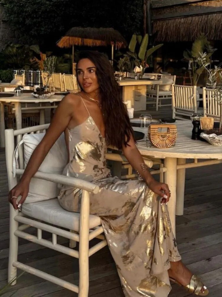 Elegant women's flowy gold backless party dress, a sleeveless midi design with a stylish deep V-neck.