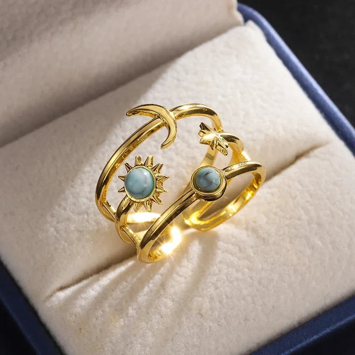 Women's gold tone celestial sunburst star ring, stainless steel with turquoise accent. Adjustable jewelry.