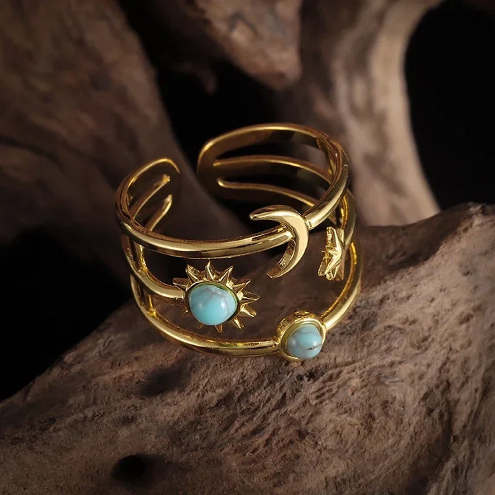 Stylish women's celestial sunburst star ring, gold tone with bright turquoise stone. Statement jewelry.