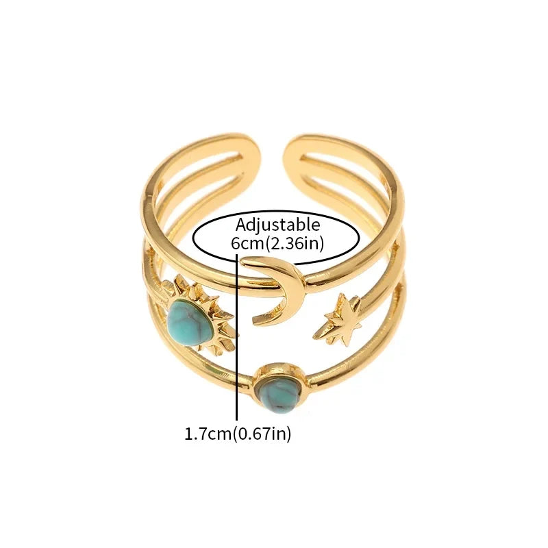 Detailed view of a women's gold tone celestial star ring featuring a sunburst design & turquoise gem.