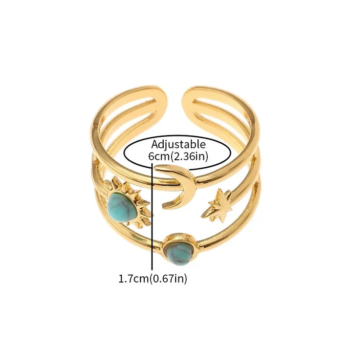 Detailed view of a women's gold tone celestial star ring featuring a sunburst design & turquoise gem.