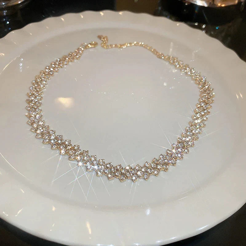 Close-up of Golden Gala Rhinestone Geometric Necklace, intricate gold design with sparkling crystals.