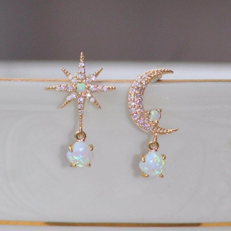 Shimmering women's golden celestial earrings with moon and star designs, embedded with beautiful opal stones.
