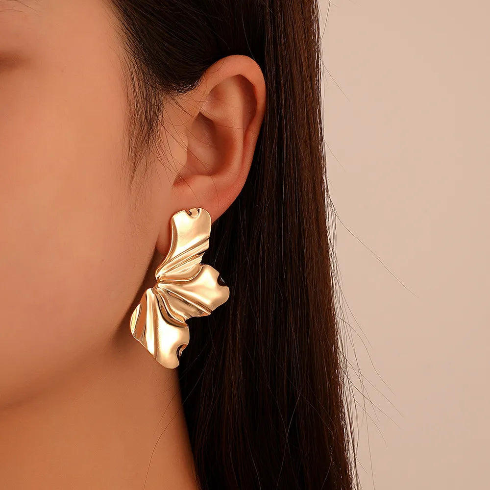 Nature-inspired golden petal stud earrings for women, delicate floral jewelry.