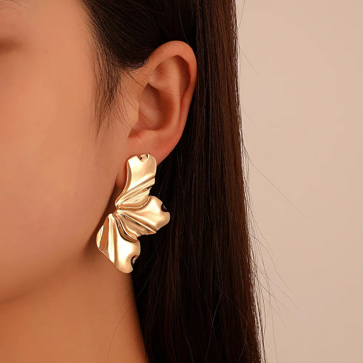 Nature-inspired golden petal stud earrings for women, delicate floral jewelry.