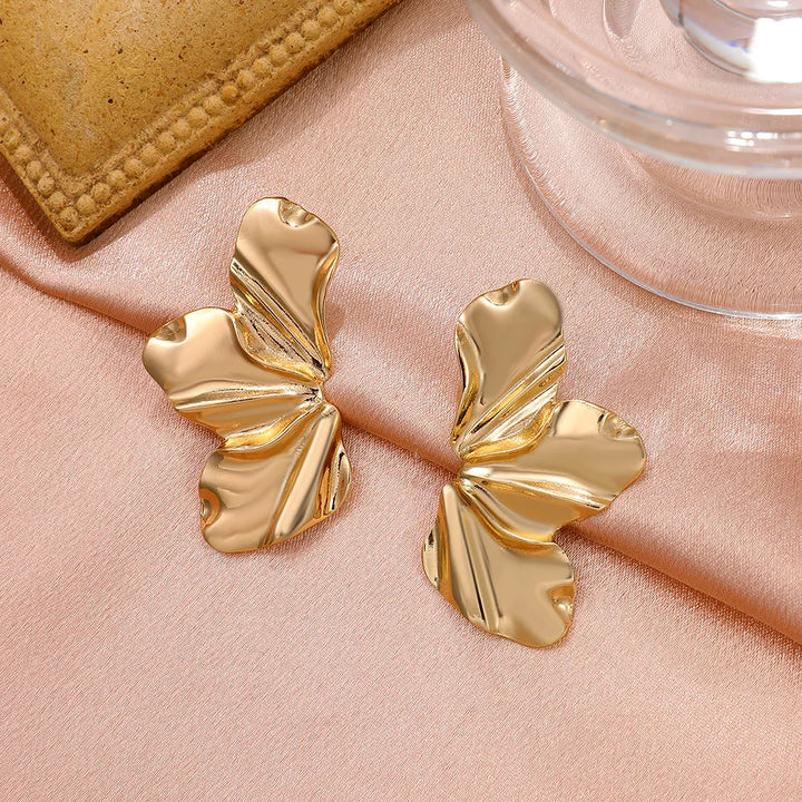 Women's elegant gold studs with intricate petal design, stunning floral jewelry.