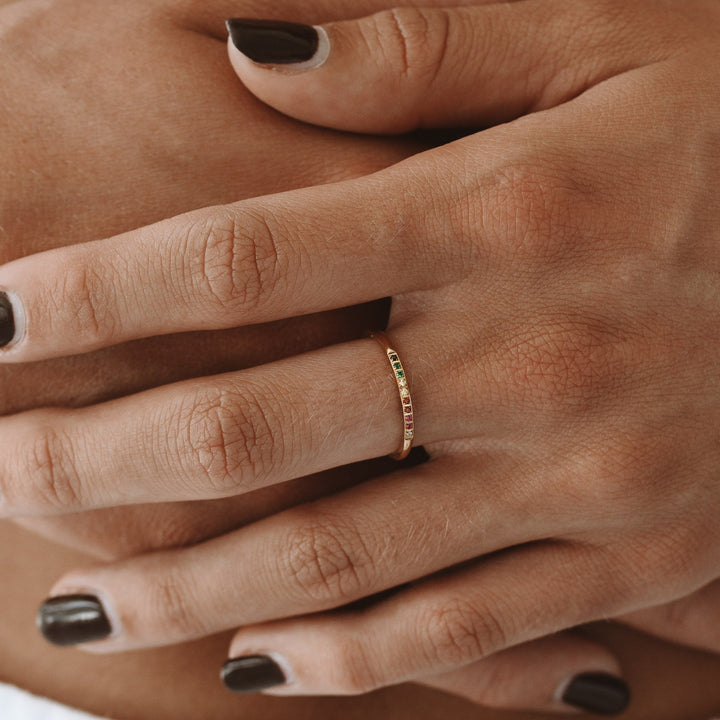 Fashionable women's gold statement ring, featuring an array of colorful gemstone accents.