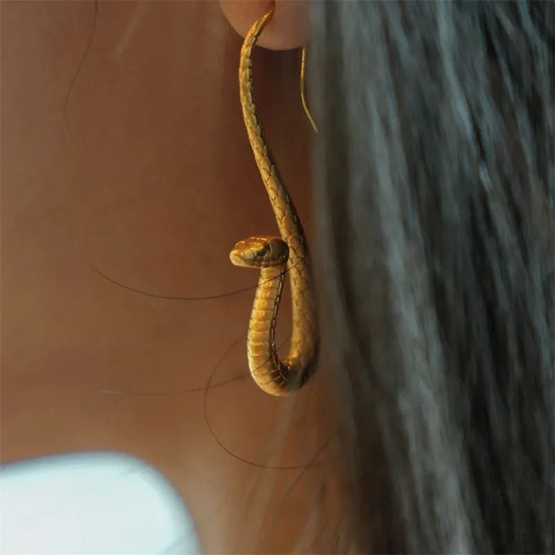 Women's golden snake drop earrings, elegant animal jewelry for a stylish statement accessory.