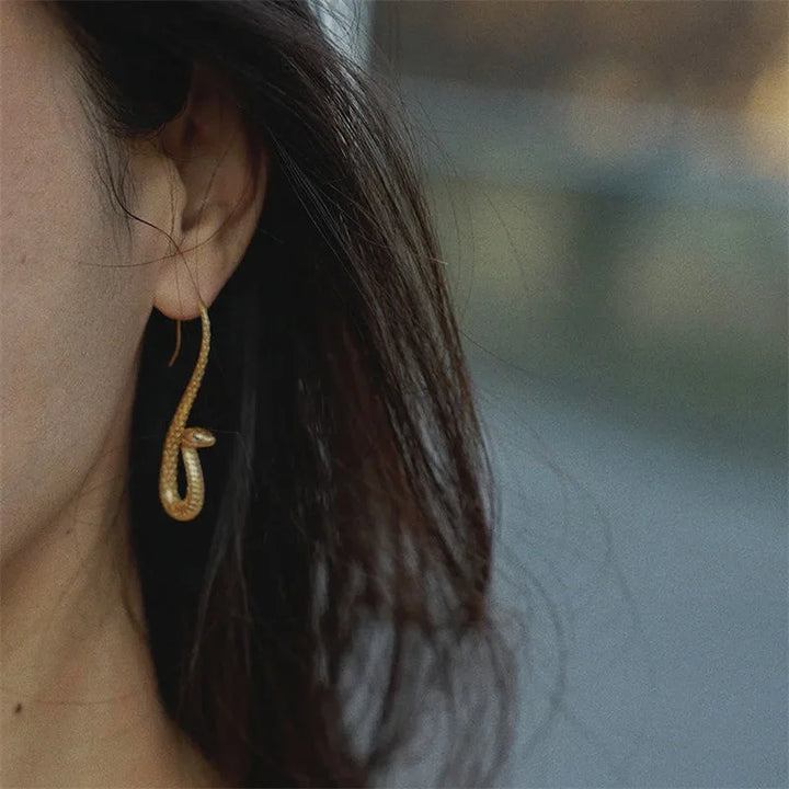 Golden snake drop earrings for women, striking animal jewelry and a trendy fashion statement accessory.