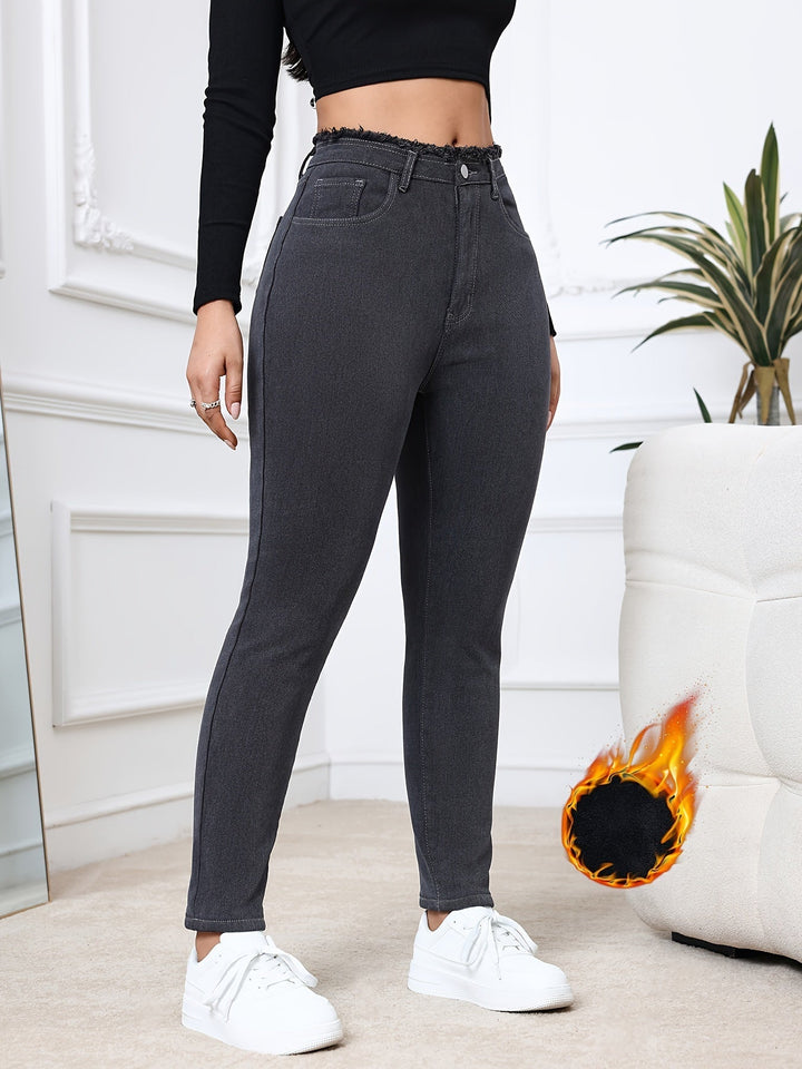 Woman wearing gray insulated skinny jeans, keeping warm & stylish in cold weather.