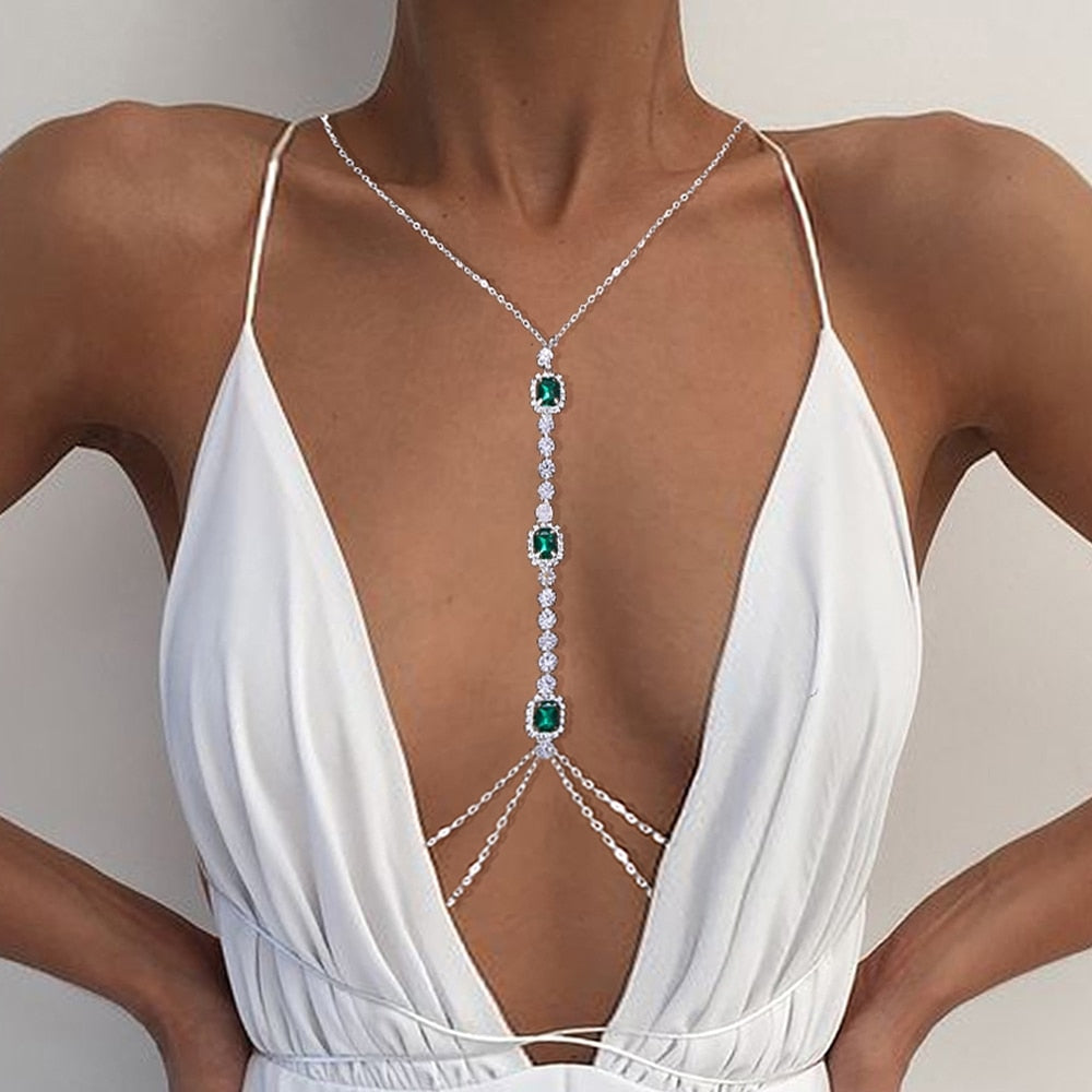 Gold-tone green crystal body chain, a sparkling women's fashion jewelry accessory. Rhinestone chest chain for events.