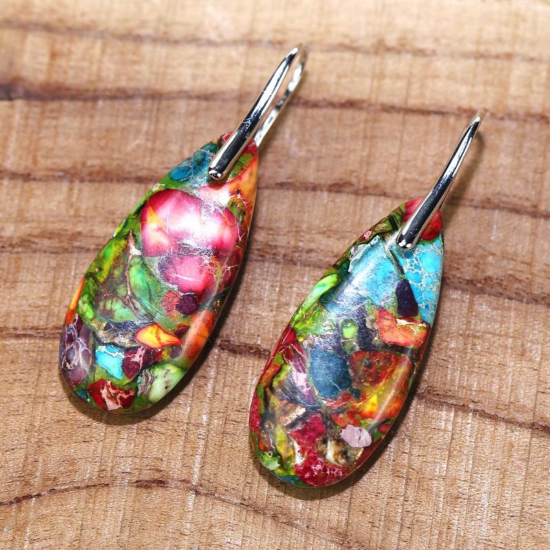 Woman wearing unique spiritual jasper drop earrings. Handcrafted gemstone jewelry, perfect for a calming touch.