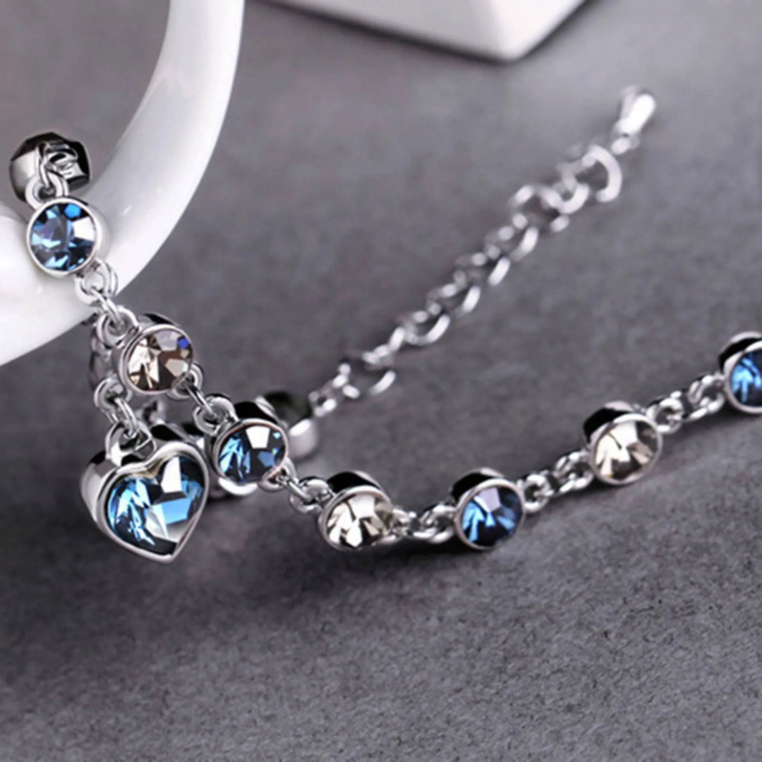 Women's Heart of the Ocean crystal bracelet worn on wrist, showcasing its elegant sparkle & adjustable fit.