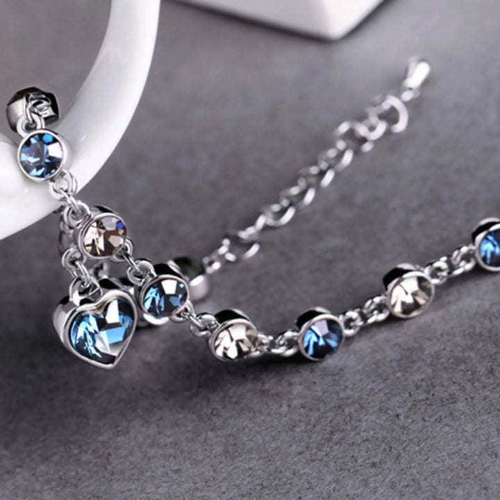 Women's Heart of the Ocean crystal bracelet worn on wrist, showcasing its elegant sparkle & adjustable fit.