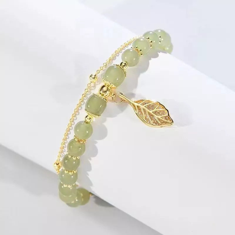 Elegant women's Hetian Jade bracelet with a subtle gold accent, a classic and beautiful gemstone wrist accessory.