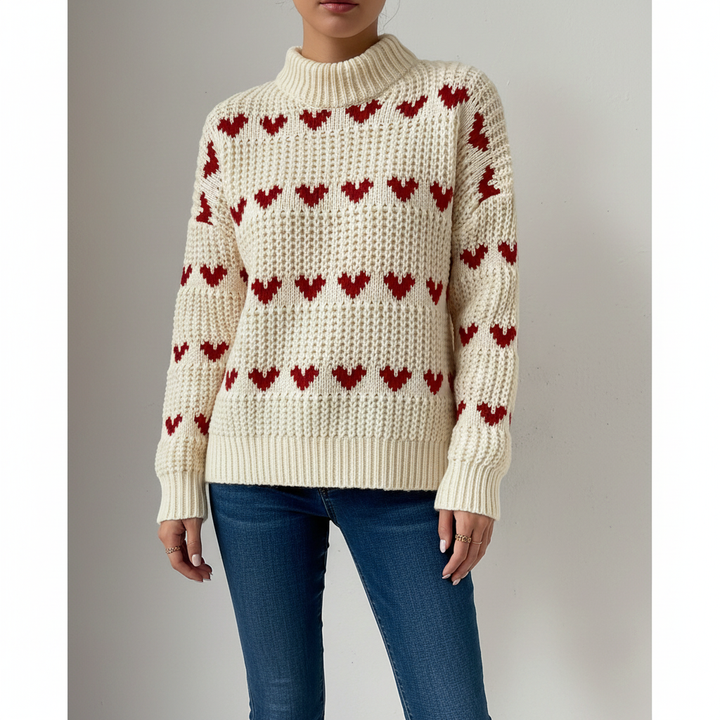 Close-up of heart pattern on women's pink high collar sweater, soft acrylic knit texture