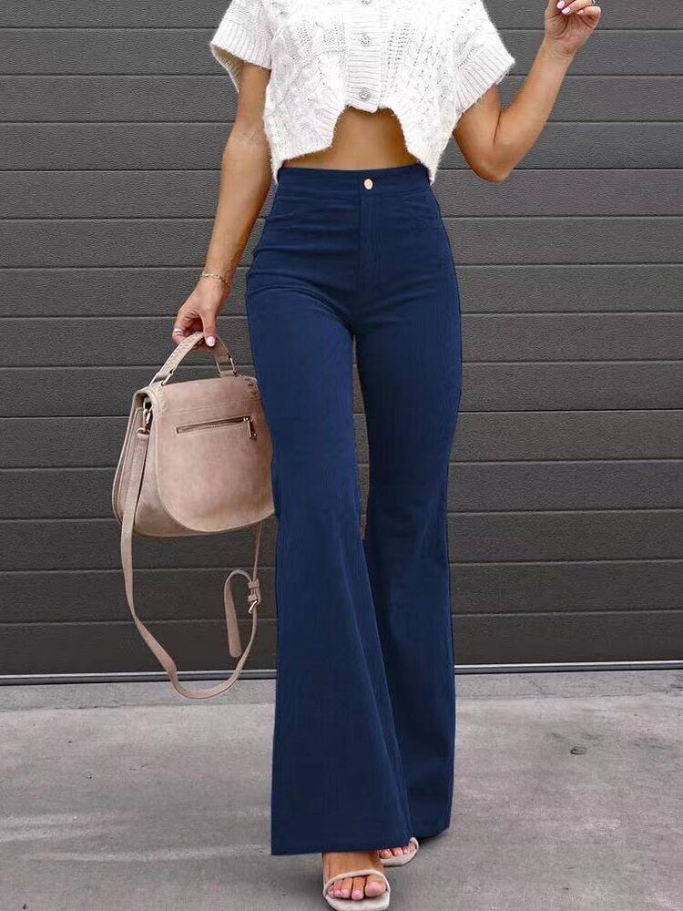 Close-up of the high waist and practical pockets on women's fashionable black flare pants.