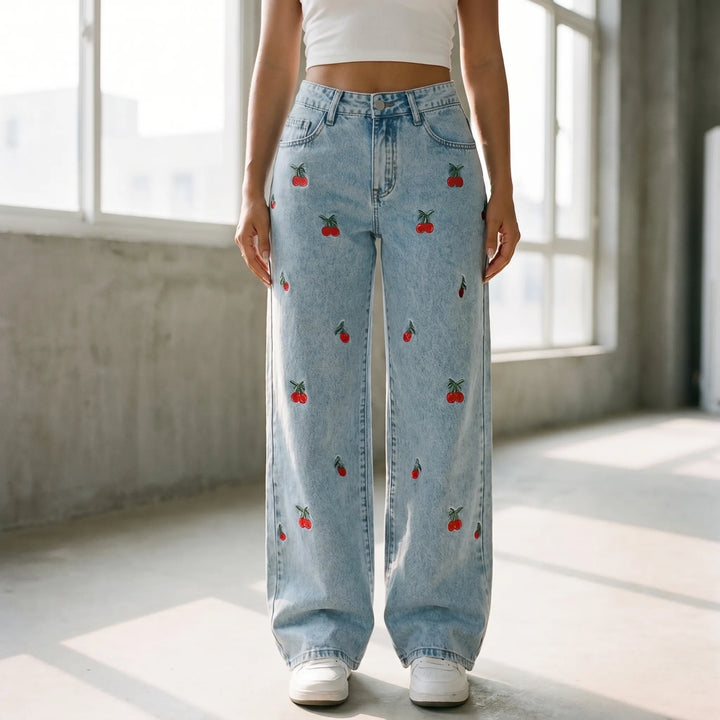 Women's high-waisted, wide-leg light wash jeans with playful cherry embroidery, perfect for casual streetwear.