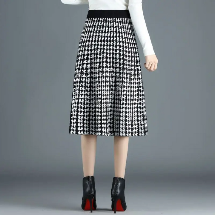 Chic women's houndstooth A-line midi skirt with pleats. Sophisticated high-waist design, versatile for office or fall.