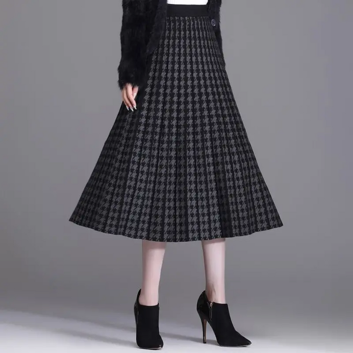 Sophisticated women's pleated A-line skirt, houndstooth pattern. High-waist midi length, elegant for office or fall fashion.