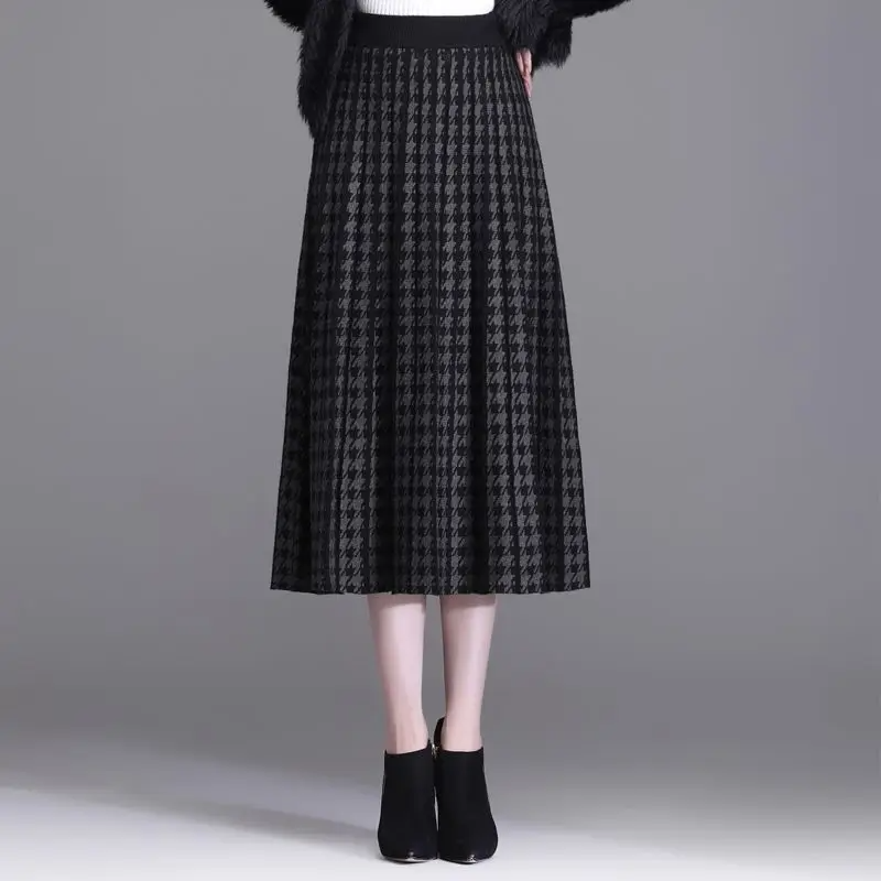 Versatile women's houndstooth midi skirt with elegant pleats. High-waist A-line design, chic for fall and winter office.