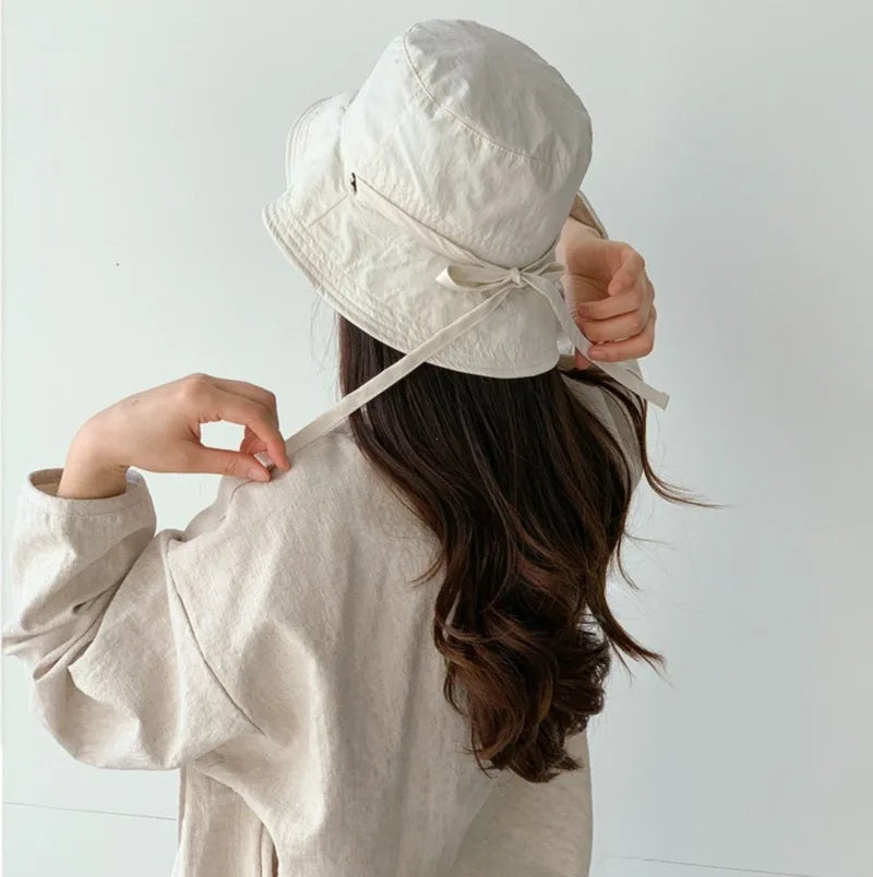 Women's travel hat, lace-up fisherman design, essential for sunny adventures & protection.
