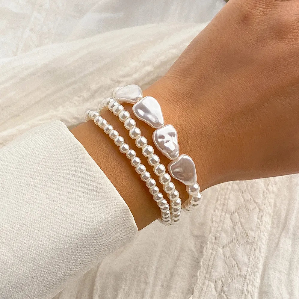 Women's layered pearl bracelet featuring delicate freshwater pearls on a stainless steel chain. Elegant & adjustable.