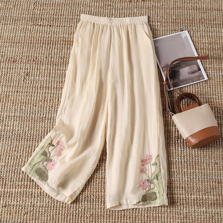 Vibrant floral print on comfortable cotton blend women's summer trousers, ideal for stylish casual wear.