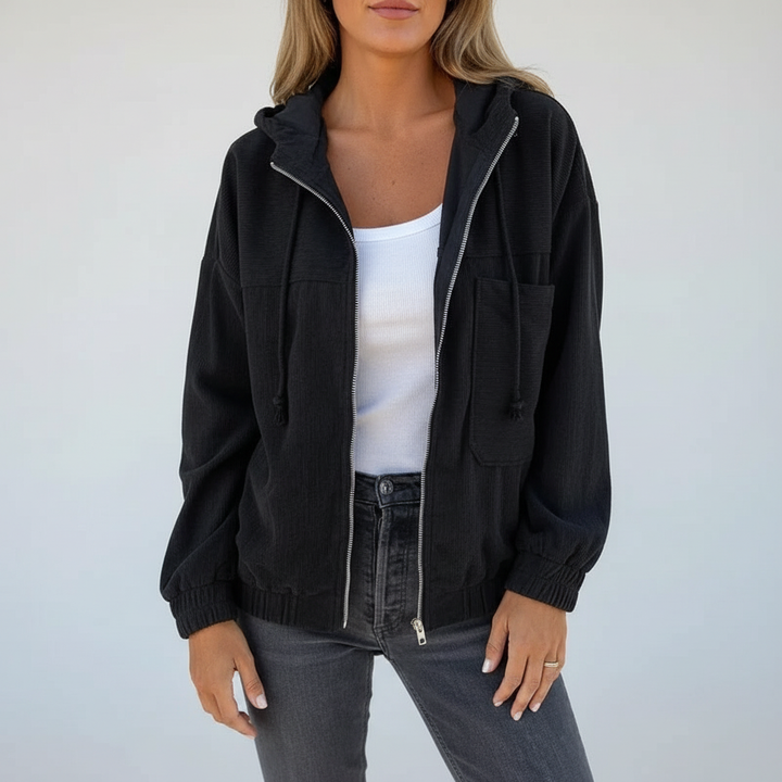 Woman zipping up a pink Regina hooded jacket, demonstrating its practicality for spring autumn