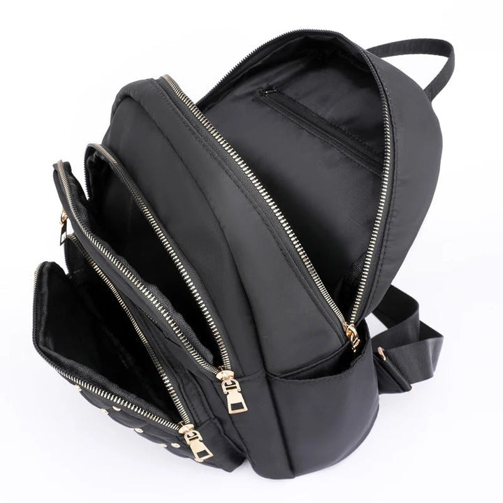 Open women's lightweight nylon backpack revealing spacious interior & organizational pockets. Great for school & travel.