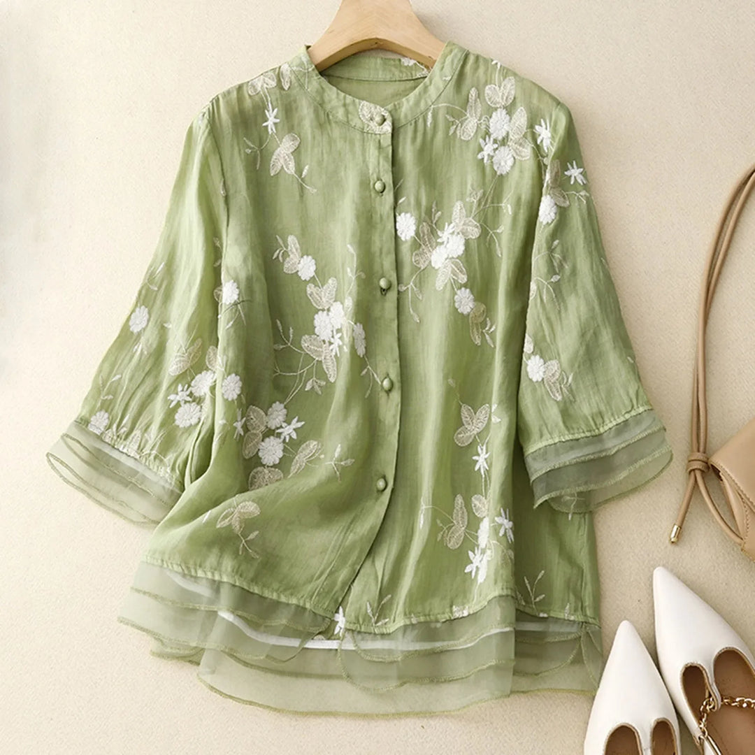 Flowy Élodie Bloom sheer blouse with delicate floral embroidery, perfect for casual chic daytime wear.