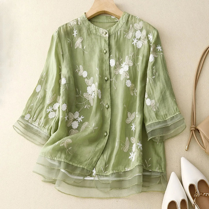 Flowy Élodie Bloom sheer blouse with delicate floral embroidery, perfect for casual chic daytime wear.