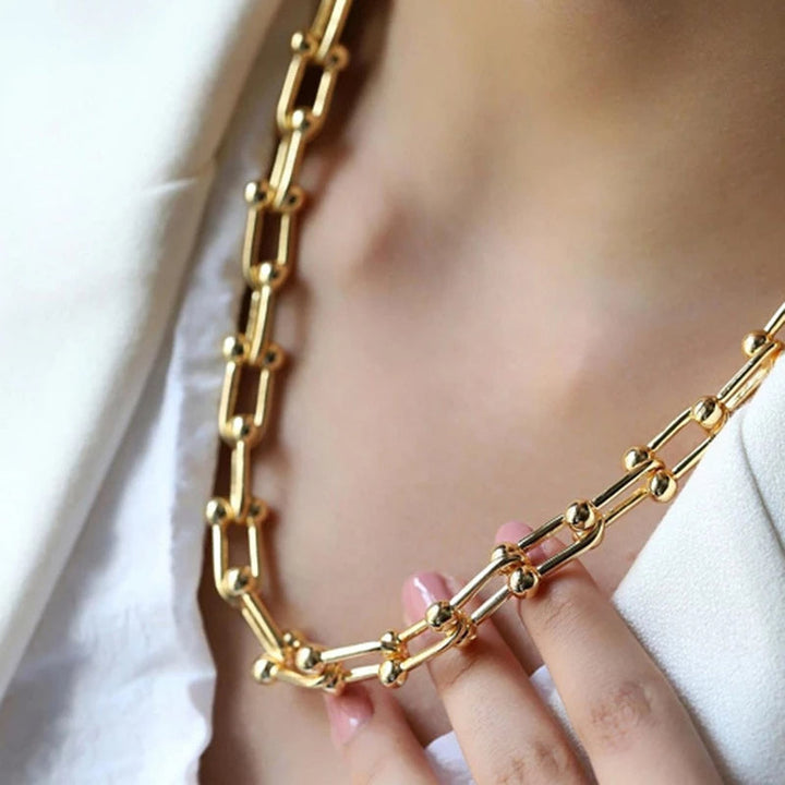 Model showcasing elegant Lumiere gold link chain necklace. Versatile women's jewelry, premium plated finish.